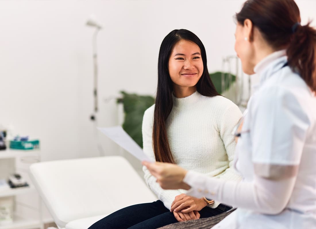 Employee Benefits - Patient Talking With a Doctor While Sitting in a Medical Office